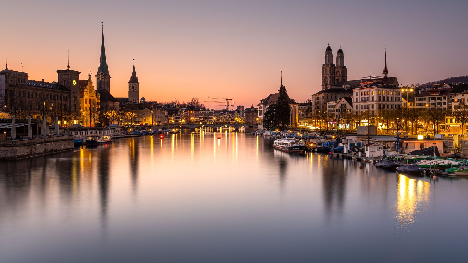 Zurich at dusk with the Limmat river, old town and church towers